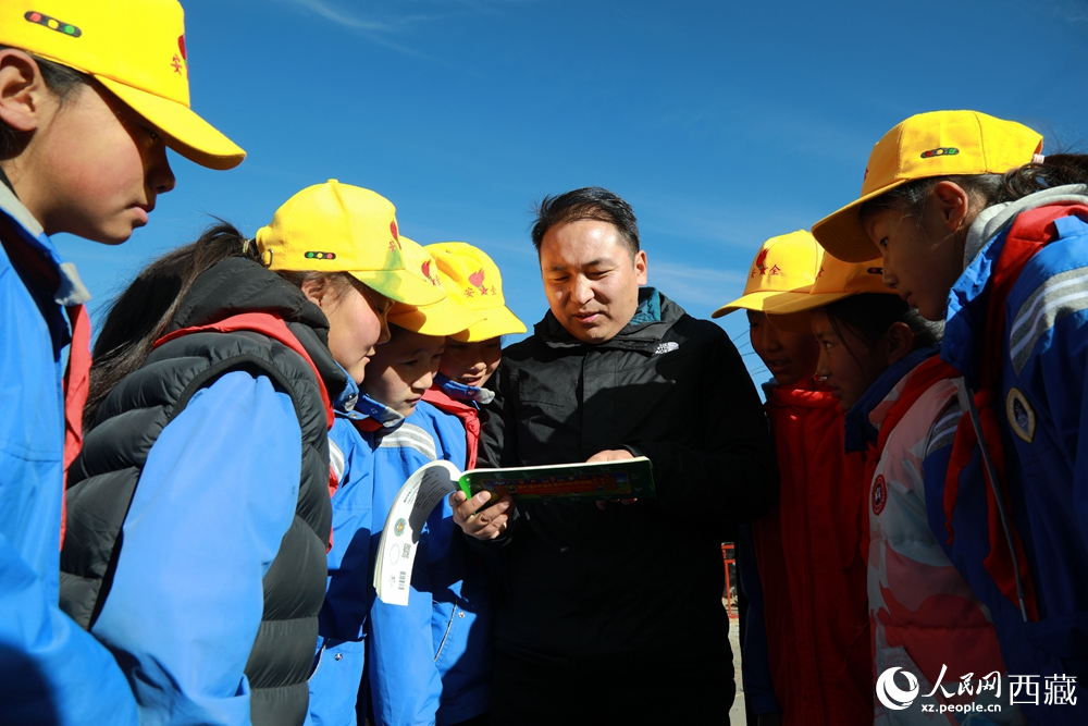 西藏自治區(qū)藏醫(yī)院專家為拉東村小學(xué)生講解天文歷算原理，孩子們圍站聆聽，感受傳統(tǒng)智慧與現(xiàn)代科普的融合。人民網(wǎng)記者 吳雨仁攝