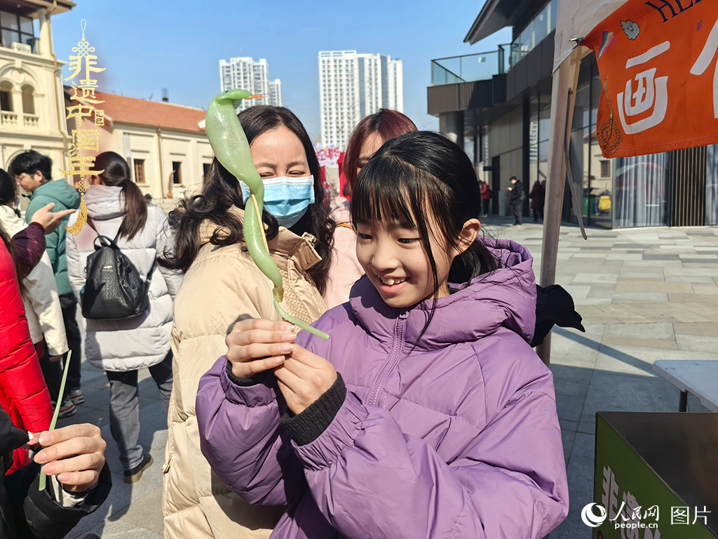 2025年1月29日，湖北武漢的新春廟會(huì)上，小朋友拿著吹制好的糖人，十分開心。人民網(wǎng)記者 張沛攝