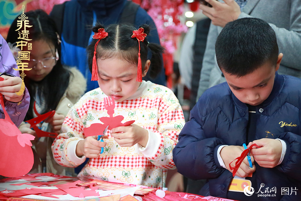 2025年1月23日，上海市青少年活動(dòng)中心迎新春游園會(huì)上，小朋友們正在學(xué)習(xí)剪窗花。人民網(wǎng)記者 龔莎攝