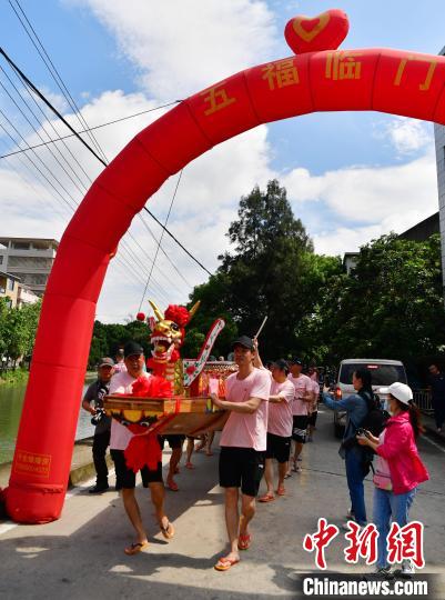 圖為5月29日，長(zhǎng)樂(lè)江田鎮(zhèn)村民們推著新龍舟前行。　張斌 攝