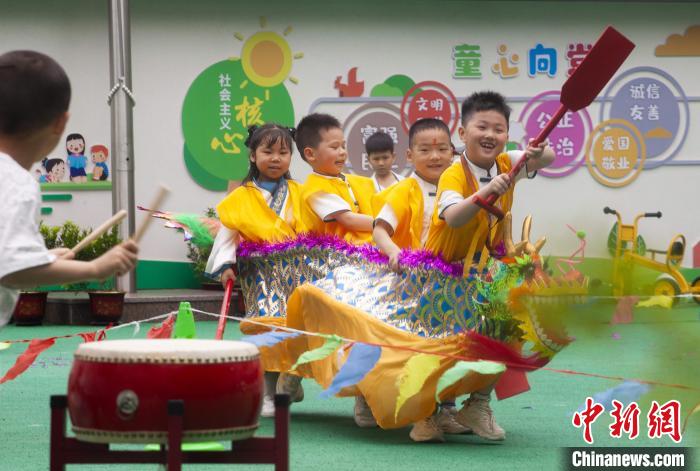 圖為龍舟賽游戲上，小伙伴們打鼓加油。　董觀生 攝